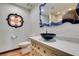 Bathroom boasts a modern sink, unique blue mirror, and decorative tile at 3990 Melody Ln, Las Vegas, NV 89108