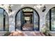 Elegant entry with arched double doors and brick walkway at 3990 Melody Ln, Las Vegas, NV 89108