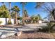 House with circular driveway, palm trees, and desert landscaping at 3990 Melody Ln, Las Vegas, NV 89108