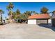 Home with attached garage, large driveway and palm trees at 3990 Melody Ln, Las Vegas, NV 89108