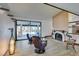 Relaxing living room with fireplace, large windows, and view of pool at 3990 Melody Ln, Las Vegas, NV 89108