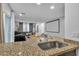 Kitchen with granite countertop, stainless steel sink and view of living room at 4070 Emerald Wood St, Las Vegas, NV 89115