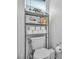 Toilet with shelving unit, rolls of toilet paper, and air freshener at 4070 Emerald Wood St, Las Vegas, NV 89115