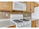 White appliances and oak cabinets in this kitchen at 4176 Demoline Cir, Las Vegas, NV 89141