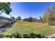 Green grassy park area with mature trees and a tennis court in the background at 4176 Demoline Cir, Las Vegas, NV 89141