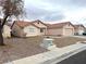 Exterior view of a tan single-story home with desert landscaping and a red tiled roof on an overcast day at 4618 Zia Ridge St, North Las Vegas, NV 89031