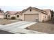 Tan house with a two-car garage and gravel driveway at 4618 Zia Ridge St, North Las Vegas, NV 89031