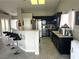 Open concept kitchen with stainless steel appliances, black cabinetry, breakfast bar and wood-look flooring at 4618 Zia Ridge St, North Las Vegas, NV 89031