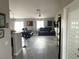 Open concept living room with wood-look floors, neutral walls, ceiling fan, and sliding glass door at 4618 Zia Ridge St, North Las Vegas, NV 89031