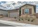 Single-story home with a two-car garage and landscaped front yard at 473 Harvest Rain Ave, Henderson, NV 89011