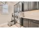 Laundry room with dark cabinets, countertop, and stainless steel washer and dryer at 473 Harvest Rain Ave, Henderson, NV 89011