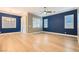 Living room with hardwood floors, plantation shutters and blue accent wall at 473 Harvest Rain Ave, Henderson, NV 89011