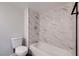 Clean bathroom featuring a bathtub, shower, and marble-tiled walls at 5129 Del Monte Ave, Las Vegas, NV 89146