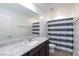 Bathroom with granite countertop and striped shower curtain at 521 Abrazar Ave, North Las Vegas, NV 89081