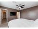 Spacious bedroom with ceiling fan, TV, and access to hallway at 521 Abrazar Ave, North Las Vegas, NV 89081