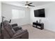 Gathering room with large TV, reclining sofa, and ceiling fan at 521 Abrazar Ave, North Las Vegas, NV 89081