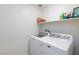 Laundry room with washer, dryer, and storage shelves at 521 Abrazar Ave, North Las Vegas, NV 89081