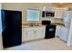 Modern kitchen with white cabinets, black appliances, and tile floor at 624 D Ave, Boulder City, NV 89005