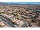 Aerial view showing a residential area with houses, roads, and a park at 6420 Birdcall St, North Las Vegas, NV 89084