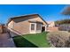 Artificial turf backyard with gravel and mature shrubs at 6420 Birdcall St, North Las Vegas, NV 89084