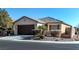 Single-story house with brown garage door and landscaped front yard at 6420 Birdcall St, North Las Vegas, NV 89084