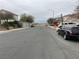 Residential street view with parked cars and distant mountains at 6556 Mount Roy Ln, Las Vegas, NV 89156