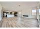Open-concept living space with a sleek fireplace, hardwood floors, and views of the modern kitchen and dining area at 66 Ibiza Lake Dr, Henderson, NV 89011
