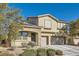 Two-story house with tan exterior, stone accents, solar panels, and a two-car garage at 7528 Stray Horse Ave, Las Vegas, NV 89113