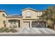 Two-story house with tan exterior, stone accents, and a two-car garage at 7528 Stray Horse Ave, Las Vegas, NV 89113