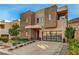 Modern two-story home with stone accents and a glass garage door at 821 Barrhead Ave, Henderson, NV 89012