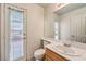 Bright bathroom featuring a vanity sink, large mirror, and a door leading to outdoor at 86 Myrtle Beach Dr, Henderson, NV 89074