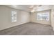 Well-lit bedroom with ceiling fan, carpet flooring, and natural light from two windows at 86 Myrtle Beach Dr, Henderson, NV 89074