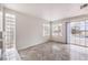 Living area with gray tile floors, two windows, a modern fireplace, and sliding glass door to patio and pool at 86 Myrtle Beach Dr, Henderson, NV 89074