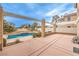 Inviting pool surrounded by a spacious deck, lush greenery, and a covered patio area at 86 Myrtle Beach Dr, Henderson, NV 89074