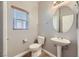 Clean powder room with pedestal sink, toilet, and oval mirror at 8658 Tom Noon Ave # 103, Las Vegas, NV 89178