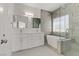 Modern bathroom with double vanity, soaking tub, and walk-in shower at 9570 Wenmarie Ct, Las Vegas, NV 89148