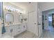 Modern bathroom with white cabinets, dual sinks, and arched mirrors at 9900 Rosamond Dr, Las Vegas, NV 89134