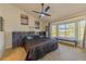 Main bedroom with large window, ceiling fan, and modern decor at 9900 Rosamond Dr, Las Vegas, NV 89134