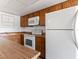 Galley kitchen with wood cabinets and white appliances at 1008 Willow Tree Dr # B, Las Vegas, NV 89128