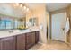 Bathroom featuring a dual sink vanity with well-lit mirror and tiled floor at 10260 Danskin Dr, Las Vegas, NV 89166