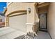 Home exterior featuring a two-car garage and a secure, decorative front door at 10260 Danskin Dr, Las Vegas, NV 89166