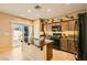 Kitchen with island, dark wood cabinets, granite countertops, and sliding door to patio at 10260 Danskin Dr, Las Vegas, NV 89166