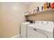 Functional laundry room with washer, dryer, and shelving for storage at 10260 Danskin Dr, Las Vegas, NV 89166