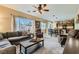 Bright living room featuring a ceiling fan, large windows and an open floor plan at 10260 Danskin Dr, Las Vegas, NV 89166