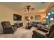 Living room with sectional sofa, two armchairs, and a large TV at 10260 Danskin Dr, Las Vegas, NV 89166