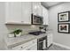 Modern kitchen with white cabinets, granite countertops, and stainless steel appliances at 104 Alamere Falls Dr, Las Vegas, NV 89138