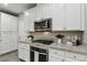 The kitchen features white cabinets, quartz countertops, and stainless steel appliances at 104 Alamere Falls Dr, Las Vegas, NV 89138