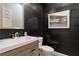 Chic powder room featuring dark paneled walls, modern vanity, and a decorative mirror, creating an elegant, contemporary space at 104 Alamere Falls Dr, Las Vegas, NV 89138