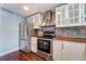 Updated kitchen featuring stainless steel appliances, white cabinets and dark wood floors at 109 Ayesha Ln, Henderson, NV 89074