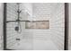 Glass-enclosed shower with white subway tile and decorative tile accent niche at 109 Ayesha Ln, Henderson, NV 89074